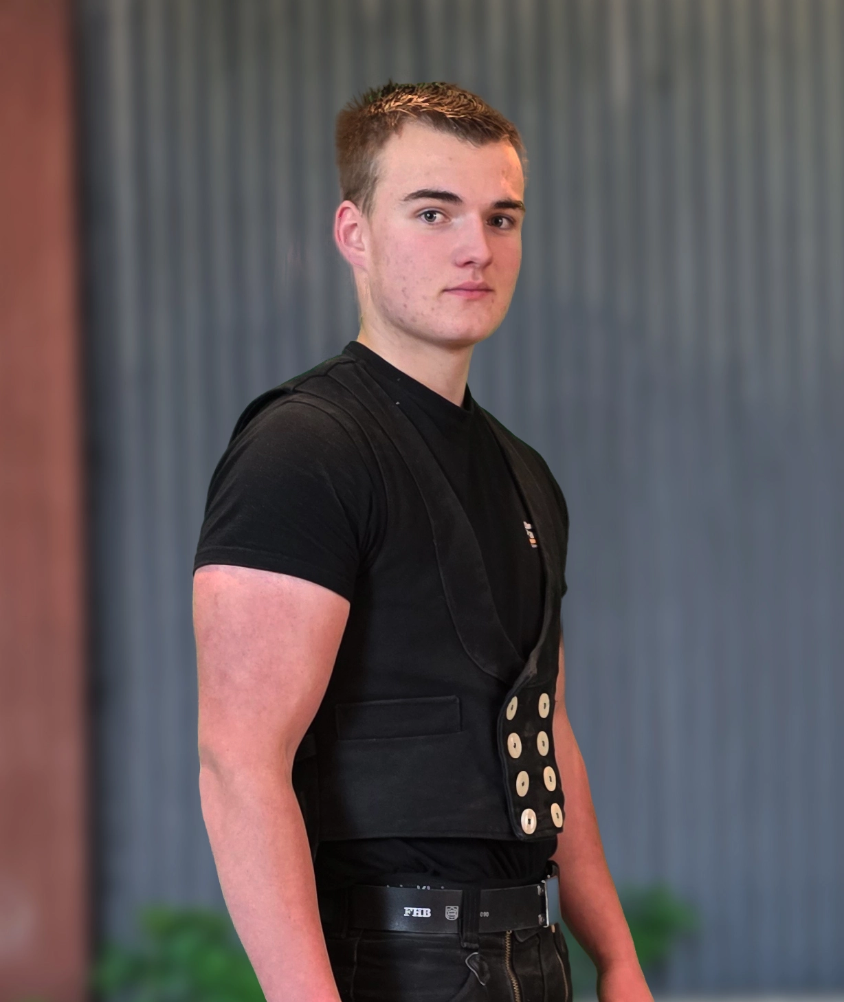 Farin Fischer, Zimmermann der Zimmerei Pawlowski GmbH, in traditioneller Arbeitskleidung mit FHB-Gürtel.