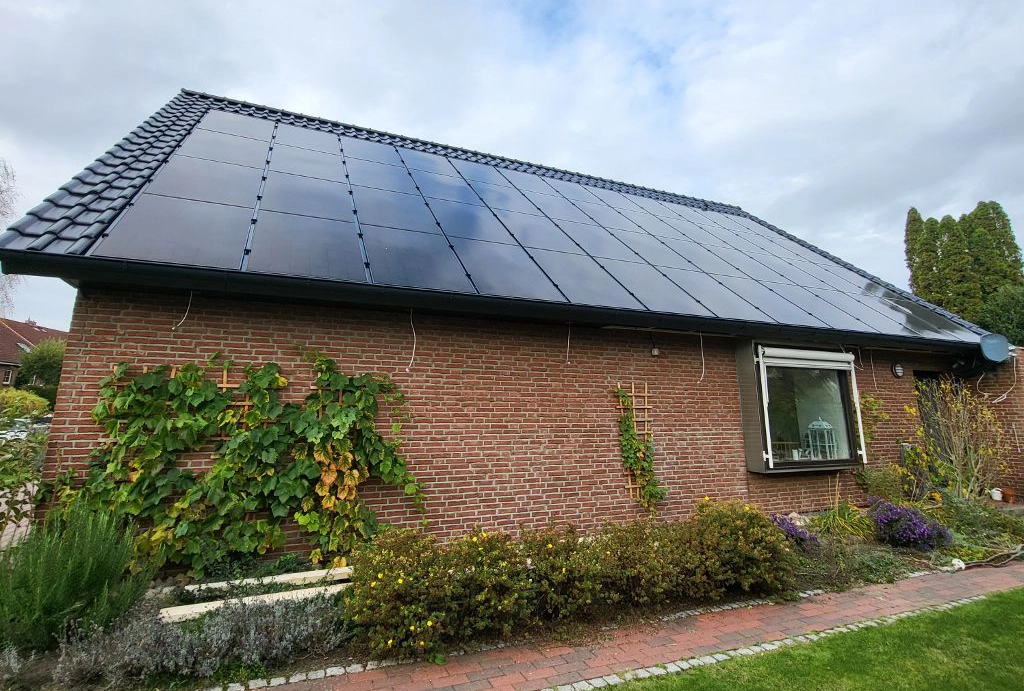 Modernes Einfamilienhaus mit neu installiertem Ziegeldach und großflächiger Photovoltaikanlage, die nachhaltige Energieerzeugung ermöglicht.