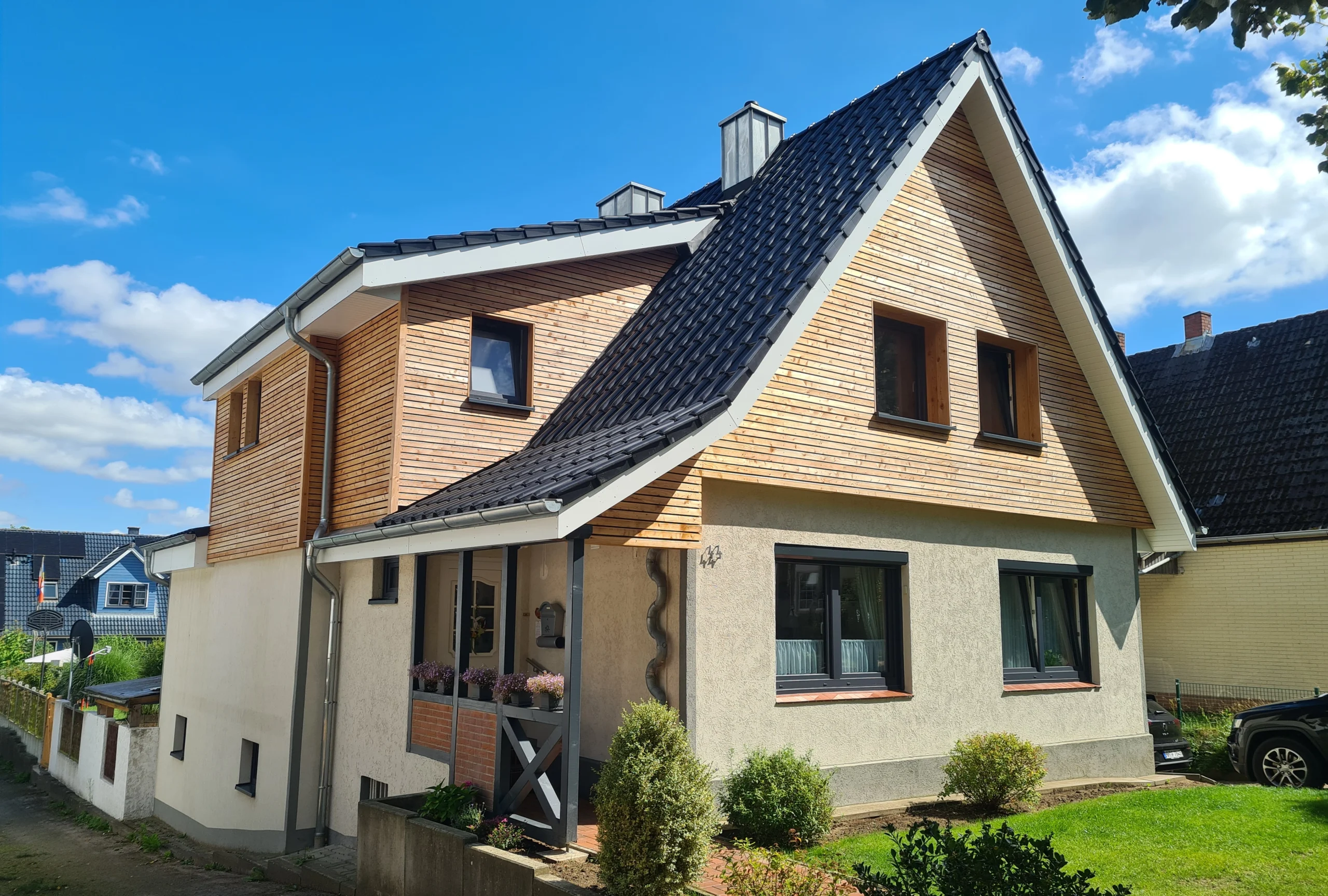 Hochwertige Holzfassade und Dachdeckung an einem modernen Einfamilienhaus, realisiert von erfahrenen Zimmerern.