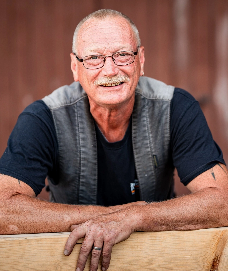 Porträt von Thomas Schop, einem erfahrenen Mitarbeiter der Zimmerei Pawlowski GmbH, der freundlich in die Kamera lächelt.